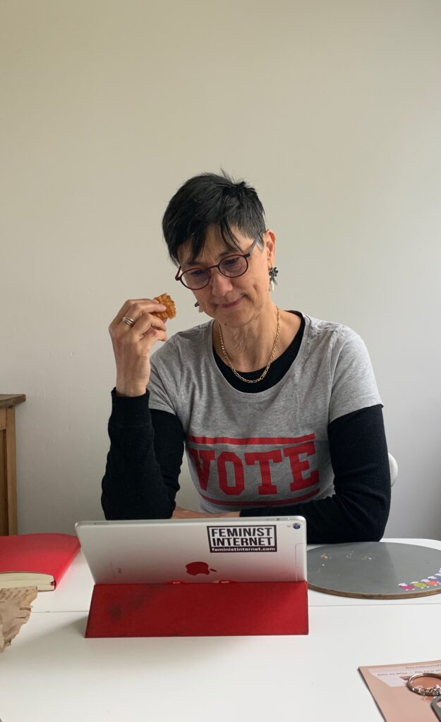 Katie sitting at her iPad, reading emails. She is wearing a 'VOTE' t-shirt