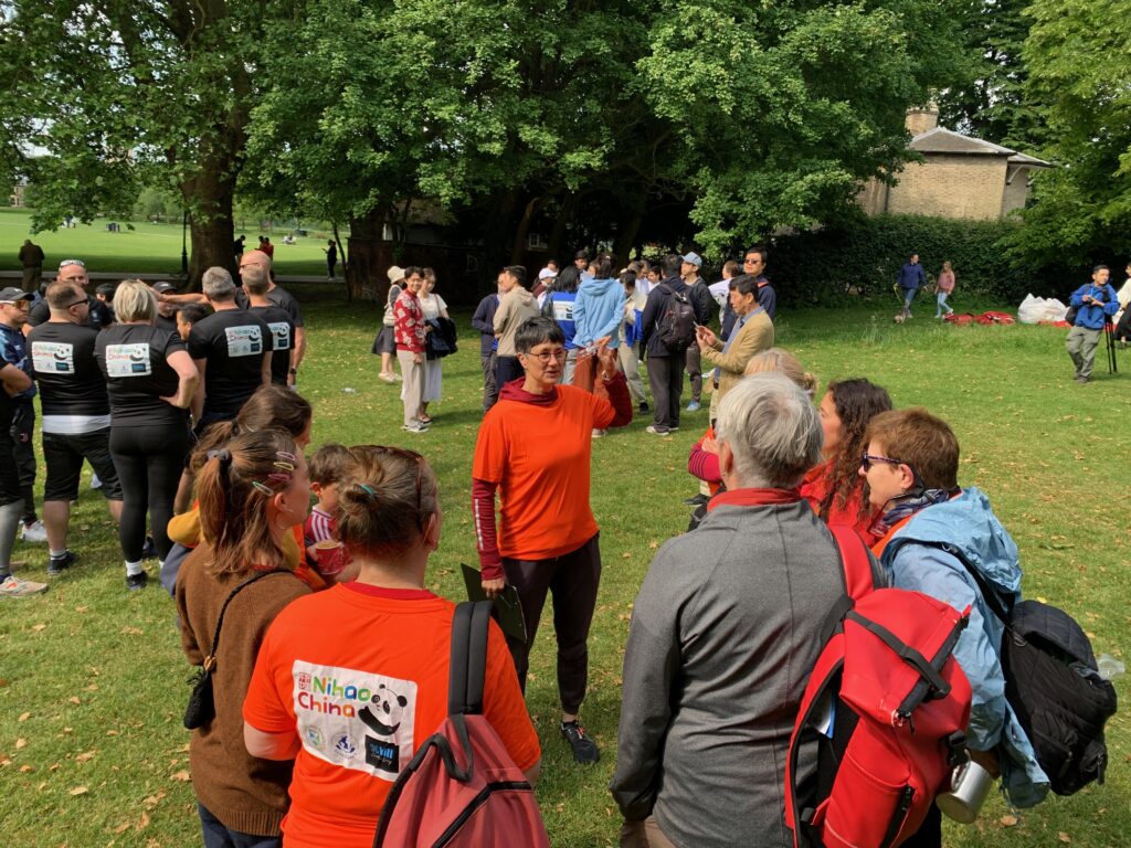 Katie, in a red t-shirt, gives a pep talk to her team before the race